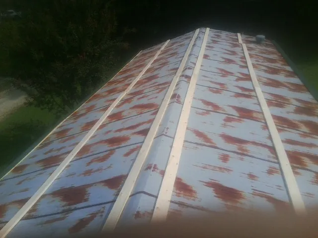 Rusted metal roof panels with new wood purlins before replacement — Storm Damage Roof Repair in Corning by Roofing Brothers